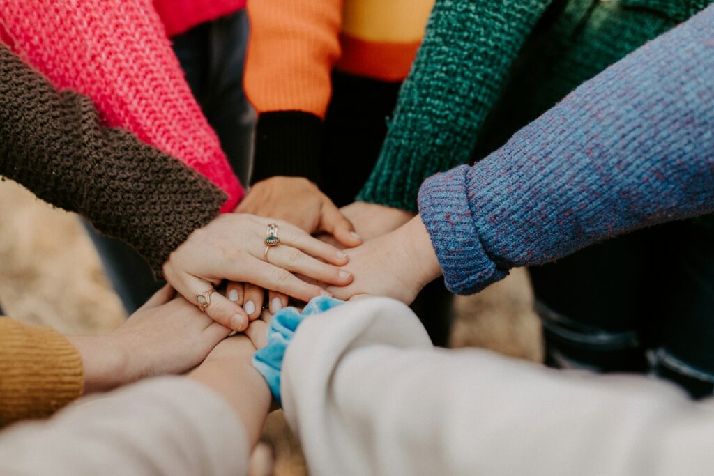 Group joining hands in teamwork unity