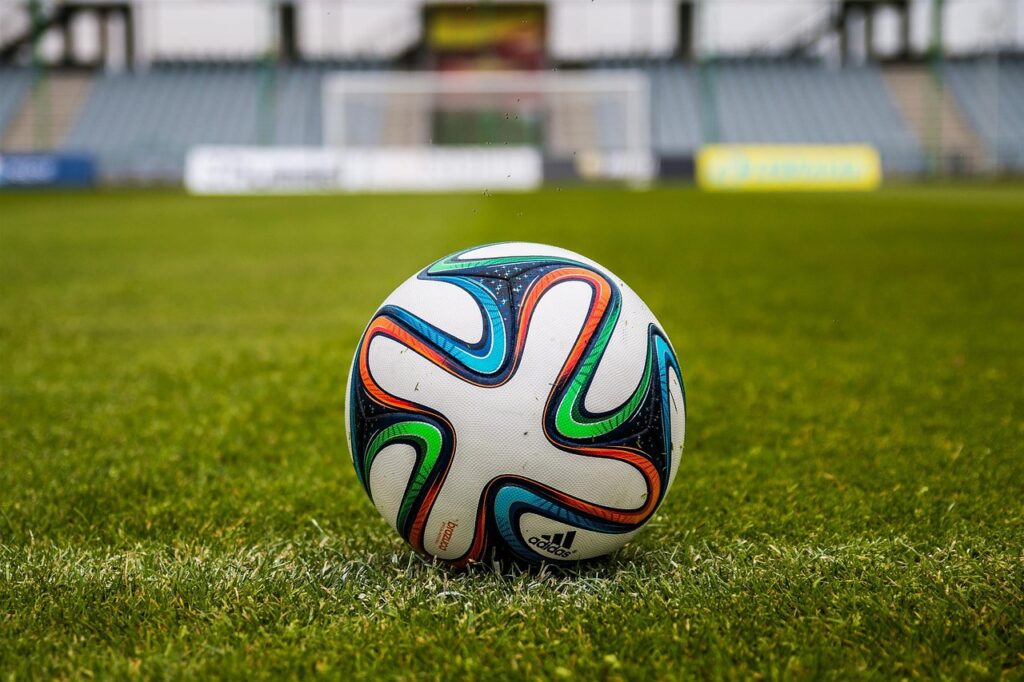 Soccer ball on green field near goalpost