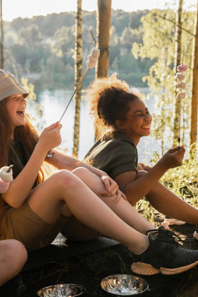 Kids roasting marshmallows by a lakeside campfire