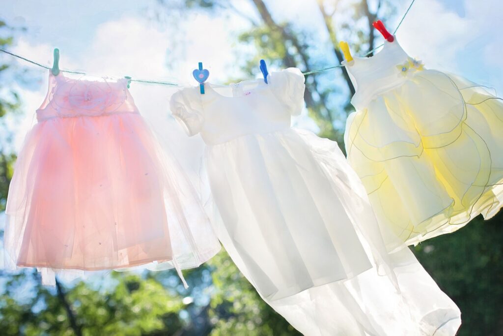 Colorful baby dresses hanging on a clothesline outdoors