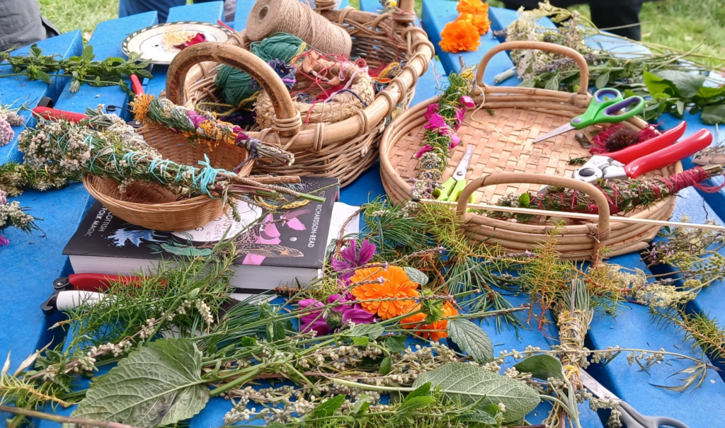 Wicker baskets with herbs and flowers on blue table