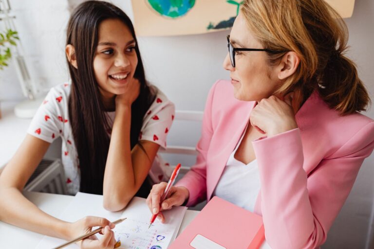 A teacher and teenager collaborate on a creative school project, promoting learning and connection.